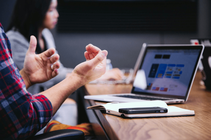 Mitarbeiter diskutieren über KPI-Dashboard-Daten auf dem Laptop